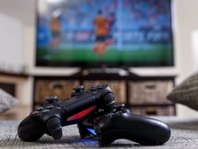 In this stock photo, a pair of video game controllers lay on the floor in front of a television.