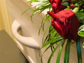 In this stock photo, a coffin sits draped in flowers.