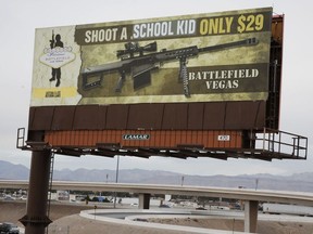 This Thursday, March 1, 2018 shows a vandalized billboard near Interstate 15 in Las Vegas. The advertisement inviting tourists to fire an assault-style rifle, which originally said "Shoot a .50 caliber only $29," was changed to say, "Shoot A School Kid Only $29."
