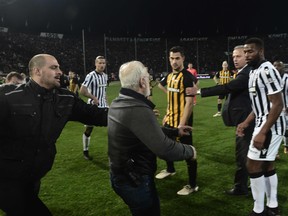 PAOK president Ivan Savvidis (C) takes to the pitch carrying a handgun in his waistband, after the referee refused a last minute goal on March 11, 2018 during the Greek Superleague football match PAOK Thessaloniki vs AEK Athens on March 11, 2018 in Thessaloniki. (STRINGER/AFP/Getty Images)