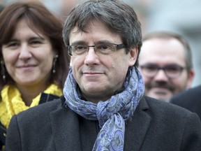 In this Friday, Jan. 12, 2018 file photo, ousted Catalan leader Carles Puigdemont stands with elected Catalan lawmakers of his Together for Catalonia party at a park in Brussels.