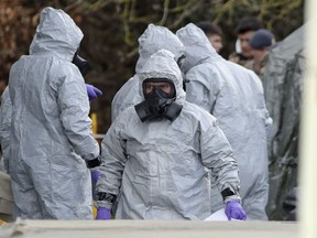 Investigators in protective clothing prepare to move an ambulance at the South Western Ambulance Service station in Harnham, near Salisbury, England, as police and members of the armed forces probe the suspected nerve agent attack on Russian spy double agent Sergei Skripal, Saturday, March 10, 2018.