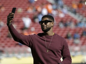 FILE - In this Feb. 7, 2016, file photo, Usher takes a selfie before the NFL Super Bowl 50 football game between the Denver Broncos and the Carolina Panthers in Santa Clara, Calif. A Concert for Peace and Justice on April 27, 2018, with a lineup that includes Usher, Common, The Roots and Kirk Franklin has been announced for the grand opening of a memorial in Alabama to victims of lynching.