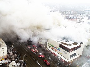 In this Russian Emergency Situations Ministry photo, on Sunday, March 25, 2018, smoke rises above a multi-story shopping center in the Siberian city of Kemerovo, about 3,000 kilometers (1,900 miles) east of Moscow, Russia. At least three children and a woman have died in a fire that broke out in a multi-story shopping center in the Siberian city of Kemerovo. (Russian Ministry for Emergency Situations photo via AP) ORG XMIT: XAZ103