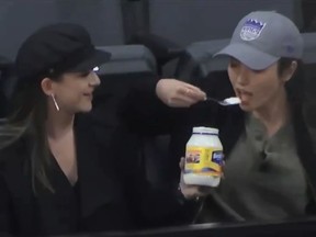 Two women were shown sharing a jar of mayonnaise during Monday's Detroit Pistons/Sacramento Kings basketball game. (Twitter/ESPN)