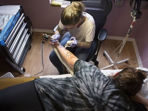 Sabrina Johnston has a Hedley-inspired tattoo covered up by tattoo artist Lizzie Renaud, owner of Speakeasy Tattoo, in Toronto on Monday, March 12, 2018.