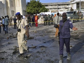 Security forces attend the scene after a car bomb explosion near the parliament building in the capital Mogadishu, Somalia Sunday, March 25, 2018. A car bomb exploded near Somalia's parliament headquarters killing a number of people and injuring others, police said.
