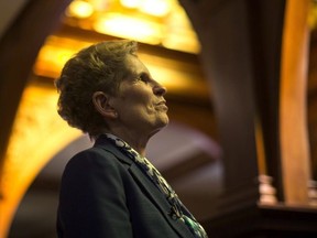 Ontario Premier Kathleen Wynne talks to a journalist in a hallway at the Ontario Legislature in Toronto on Monday, March 19, 2018.