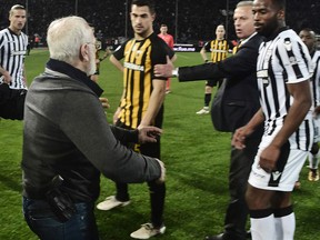 In this file photo taken on March 11, 2018 PAOK president Ivan Savvidis (left) takes to the pitch carrying a handgun in his waistband during the Greek Superleague match against AEK Athens in Thessaloniki. (Getty Images)
