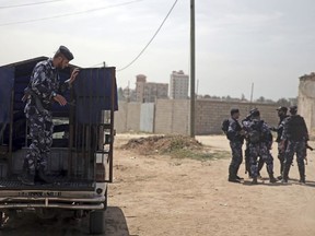 Palestinian members of the Hamas security forces patrol during an operation to arrest suspects wanted for a roadside bombing that targeted the visiting Palestinian premier's convoy in Gaza last week, in the town of Nuseirat, central Gaza Strip, Thursday, March 22, 2018.