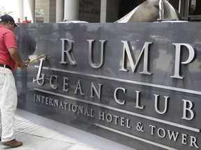A man removes the word Trump, off a marquee outside the Trump Ocean Club International Hotel and Tower in Panama City, Monday, March 5, 2018.