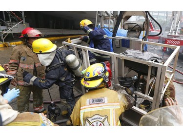 Two firemen who ran out of oxygen while searching for trapped employees are lowered to safety following a fire that engulfs the Manila Pavilion Hotel and Casino Sunday, March 18, 2018 in Manila, Philippines. (AP Photo/Bullit Marquez)