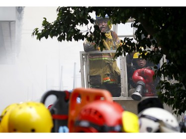 Two firemen who ran out of oxygen while searching for trapped employees are lowered to safety following a fire that engulfs the Manila Pavilion Hotel and Casino Sunday, March 18, 2018 in Manila, Philippines. (AP Photo/Bullit Marquez)