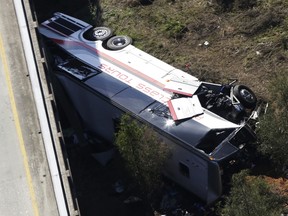 A charter bus sits in a ravine after a deadly crash on Tuesday, March 13, 2018, in Loxley, Ala. The bus carrying Texas high school band members home from Disney World plunged into the ravine before dawn Tuesday.  (AP Photo/Dan Anderson)