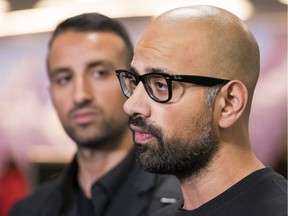 Mehran Seyed-Emami, left, listens while his brother, Ramin, speaks to reporters after arriving from Iran at Vancouver airport in Richmond on March 8.