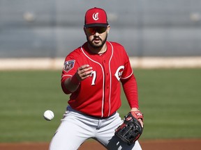 In this Feb. 20, 2018, file photo, Cincinnati Reds third baseman Eugenio Suarez flips a ball away after fielding a grounder at the team's spring training facility in Goodyear, Ariz.