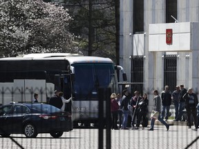 People gather and board a bus at the Russian Embassy in Washington, Saturday, March 31, 2018. (AP Photo/Carolyn Kaster)