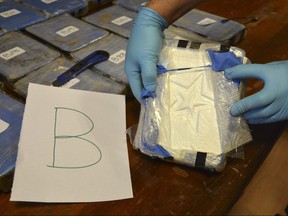 In this file photo taken on Dec. 14, 2016, and released on Feb. 22, 2018 by the Argentine Security Ministry, a police officer shows a package of cocaine that with a star sign, that was found in an annex building of the Russian embassy in Buenos Aires, Argentina. (Argentine Security Ministry via AP, File)