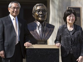 In this April 18, 2014, file photo, Nobel laureate and Purdue University professor Ei-ichi Negishi, left stands with his wife Sumire after the unveiling of a bronze sculpture of him outside of Wetherill Laboratory of Chemistry on campus at Purdue University in West Lafayette, Ind. (Michale Heinz/Journal & Courier via AP, File)