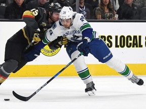 Jon Merrill of the Vegas Golden Knights hits Brandon Sutter of the Vancouver Canucks as he skates with the puck in the first period of their game at T-Mobile Arena on March 20, 2018