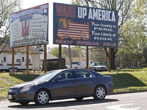 This Wednesday, March 21, 2018 photo shows billboards displaying the Ten Commandments and a flaming American flag which Wayne Wallace installed without proper permits in Brookhaven, Miss.