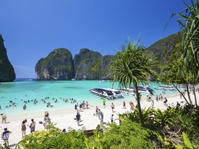 In this March 4, 2017, photo, tourists enjoy the popular Maya bay on Phi Phi island, Krabi province. Authorities have ordered the temporary closing of the beach made famous by the Leonardo DiCaprio movie "The Beach" to halt environmental damage caused by too many tourists.