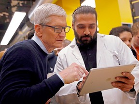 Apple CEO Tim Cook (L) gets a closer look at the new iPad and applications at Lane Tech College Prep High School in Chicago on March 27, 2018. (JIM YOUNG/AFP/Getty Images)