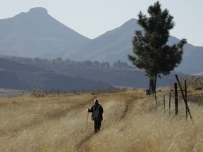 FILE - In this June 3, 2017, file photo, a man walks on the land at Ha Mampho village, Lesotho. The blockbuster film "Black Panther" has created a new compelling vision of Africa as a continent of smart, technologically savvy people with cool clothes living in a futuristic city amid stunning landscapes.