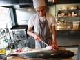 Toronto chef Dylan Vickers prepares a yellowtail fish for the evening's dinner crowd at Skippa sushi restaurant on Harbord St.  (Jack Boland/Postmedia Network)