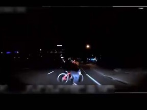 This screengrab of a video released by  Tempe Police shows a woman with her bike walking across the street the moment an Uber self-driving vehicle hit her. (Tempe Police/Twitter)