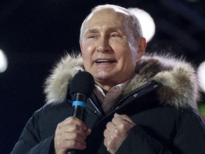 Russian President Vladimir Putin waves after speaking to supporters during a rally near the Kremlin in Moscow, Sunday, March 18, 2018.