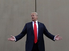 In this March 13, 2018 photo, President Donald Trump speaks during a tour as he reviews border wall prototypes in San Diego.