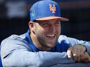 New York Mets' Tim Tebow laughs with teammates in the dugout before a spring training baseball game against the New York Yankees, Wednesday, March 7, 2018, in Port St. Lucie, Fla.. Tebow did not play.