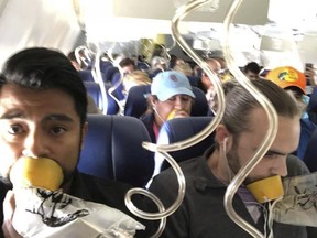 In this April 17, 2018 photo provided by Marty Martinez, Martinez, left, appears with other passengers after a jet engine blew out on Southwest Flight 1380.