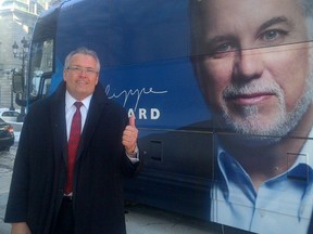 Quebec MNA Yves St-Denis gestures in front a campaign bus in 2014.