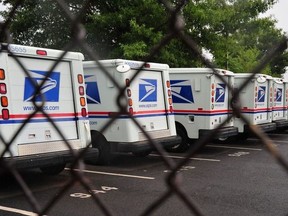 US Postal Service mail delivery trucks sit idle at the Manassas Post Office in Virginia on September 5, 2011.