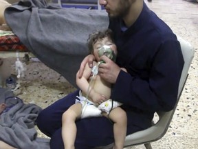 This image made from video released by the Syrian Civil Defense White Helmets, which has been authenticated based on its contents and other AP reporting, shows a medical worker giving toddlers oxygen through respirators following an alleged poison gas attack in the opposition-held town of Douma, in eastern Ghouta, near Damascus, Syria, Sunday, April 8, 2018.