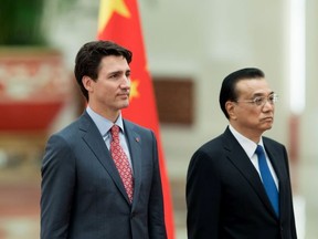 Chinese Premier Li Keqiang (R) and Canada's Prime Minister Justin Trudeau listen to their national anthems during a welcoming ceremony inside the Great Hall of the People on December 4, 2017 in Beijing, China.