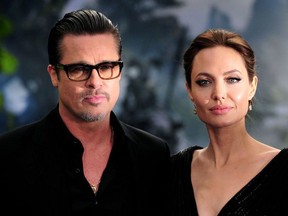 This file photo taken on May 8, 2014 shows actress Angelina Jolie (R) along with her husband actor Brad Pitt as they arrive for the premiere of the film "Maleficent" at Kensington Palace in London.