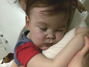 In this April 23, 2018 handout photo provided by Alfies Army Official, brain-damaged toddler Alfie Evans cuddles his mother Kate James at Alder Hey Hospital, Liverpool, England. (Alfies Army Official via AP)