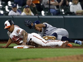 Baltimore Orioles baserunner Jace Peterson, left, steals third as Tampa Bay Rays pitcher Chris Archer falls over him while trying to make the tag Thursday, April 26, 2018, in Baltimore. (AP Photo/Patrick Semansky)