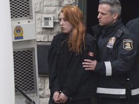 Audrey Gagnon is escorted by police on her way to the courthouse in Quebec City, Thursday, April 19, 2018. A Quebec City mother has been arrested in the slaying of her two-year-old daughter and is expected to be arraigned later today. THE CANADIAN PRESS/Jacques Boissinot