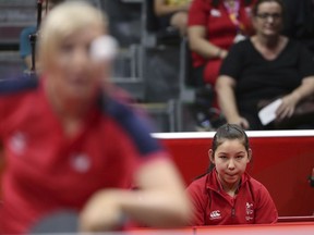 Wales' 11-year-old table tennis player Anna Hursey, right, watches teammate Charlotte Carey play against India's Manika Batra during their women's team match at the 2018 Commonwealth Games Thursday, April 5, 2018.