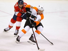 Philadelphia Flyers defenceman Shayne Gostisbehere and Florida Panthers centre Derek MacKenzie battle for the puck during an NHL game on March 4, 2018