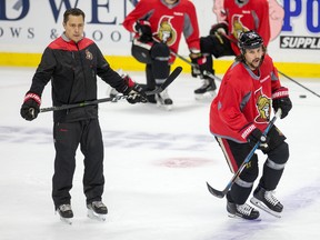 Coach Guy Boucher (left) and Erik Karlsson at a Sens practice. Will either man be back next year? (WAYNE CUDDINGTON/POSTMEDIA)