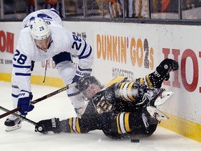 Maple Leafs forward Connor Brown vies for the puck with Bruins defenceman Torey Krug on Saturday night in Boston. (The Associated Press)