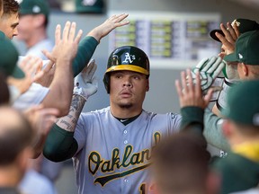 In this Sept. 2, 2017, file photo, Oakland Athletics' Bruce Maxwell is congratulated by teammates in the dugout after hitting a solo home run in Seattle. (AP Photo/Stephen Brashear, File)