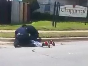 Forrest Curry, 35, lies face-down in the street as he is arrested by Fort Worth police officers on Mar. 31, 2018.