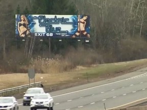 In this screenshot, a billboard for the Electric Blue Cafe in Tolland, Conn. stands alongside I-84.