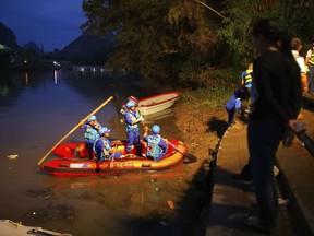 Rescuers prepare to search for missing boaters on the Taohua River in Guilin in southern China's Guangxi Zhuang Autonomous Region, Saturday, April 21, 2018. (Chinatopix via AP)